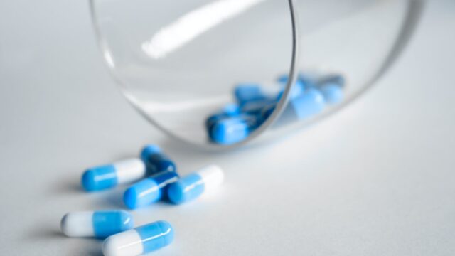 depth photography of blue and white medication pill