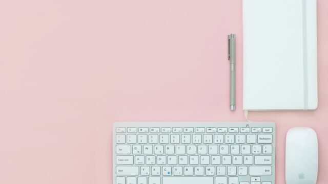 silver apple keyboard and magic mouse on a pink surface