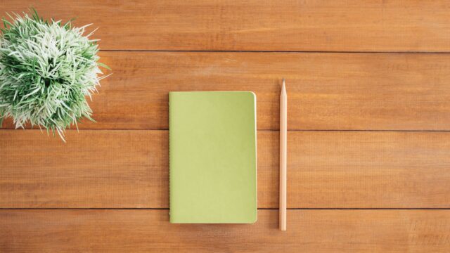 white notes beside a pencil on brown wooden surface